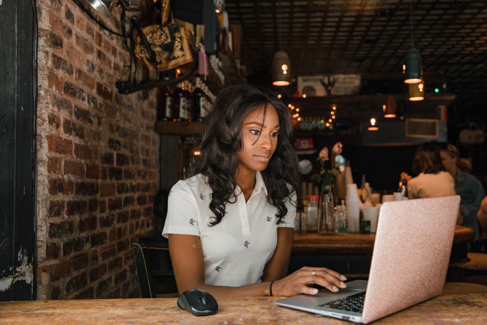 Fotografia de profissional em um café com mockup ilustrativo de site institucional.